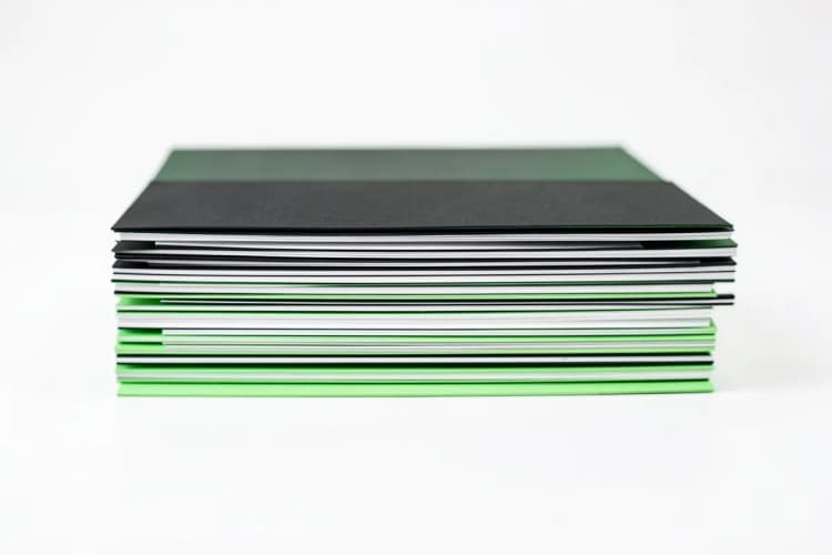 A stack of neatly organized, blank manila folders arranged in a row on a clean, white surface.