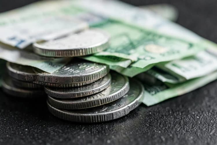 A close-up of various international currency coins and banknotes neatly stacked, symbolizing financial exchange.